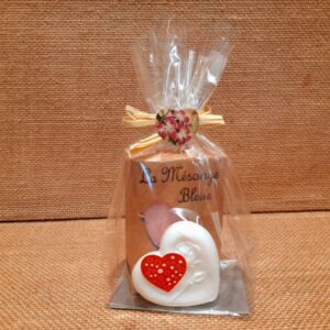 Sachet cadeau contenant un savon parfumé et un savon en forme de cœur de couleur blanc, sur un fond en jute
