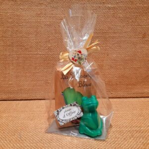 Sachet cadeau contenant un savon parfumé et un savon en forme de grenouille de couleur vert, sur un fond en jute