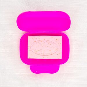Boîte à savon grand modèle de couleur fushia avec un savon rose dedans, sur un fond gris clair