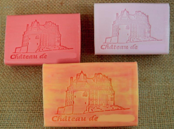 Exemple de personnalisation de 3 savons invités de couleurs différentes pour un château, sur un fond en jute