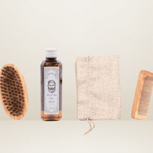 Kit pour barbe comprenant une brosse en bois, un flacon d'huile bio pour barbe, un peigne en bois et un pochon de rangement en jute, sur un fond beige