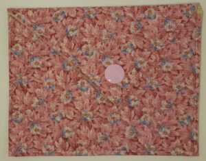 Pochette à savon Colette, vieux rose au décor floral avec un bouton pression rond de couleur rose.